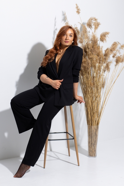 Sievietes portrets ar dabas elementiem fonā.